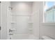 Bright bathroom features a shower-tub combo with integrated shelves and natural light from the window at 475 Queenview Ln, Charleston, SC 29414