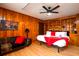 Nicely appointed bedroom with wood walls, a ceiling fan, and a full bed with a bright red blanket at 5040 Lancaster St, North Charleston, SC 29405