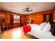 Cozy bedroom with wood walls, a ceiling fan, and a full bed with a bright red blanket at 5040 Lancaster St, North Charleston, SC 29405