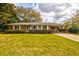 Charming red brick home with manicured lawn, carport, and lush trees offers classic curb appeal at 5040 Lancaster St, North Charleston, SC 29405