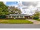 Traditional red brick home with carport, well-kept lawn, and manicured hedges creates an inviting atmosphere at 5040 Lancaster St, North Charleston, SC 29405