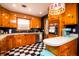Rustic kitchen with knotty pine cabinets, checkered floors, and stainless steel appliances at 5040 Lancaster St, North Charleston, SC 29405