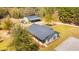 Stunning aerial view of a home with metal roof, lush landscaping, and a detached garage/workshop on a wooded lot at 508 Horse Trail Rd, Saint George, SC 29477