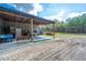 Side view of a metal barn with an attached covered area, swing bench, and open space, great for projects at 508 Horse Trail Rd, Saint George, SC 29477