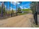 A wrought iron gate accents a long, private driveway, leading up to a charming country home at 508 Horse Trail Rd, Saint George, SC 29477