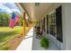 Charming front porch with rocking chairs, plants, and an American flag at 508 Horse Trail Rd, Saint George, SC 29477