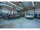 Inside a spacious garage with high ceilings, exposed beams, and ample workspace featuring a car lift, and classic car at 508 Horse Trail Rd, Saint George, SC 29477