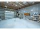 A well-lit garage space with exposed ceiling beams, offering functional storage and workspace with natural lighting at 508 Horse Trail Rd, Saint George, SC 29477