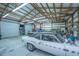 Spacious garage/workshop interior with roll-up door, and high ceilings with exposed beam, and a white classic car at 508 Horse Trail Rd, Saint George, SC 29477