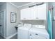 Laundry room featuring modern appliances, overhead cabinets, and a vintage utility sink at 508 Horse Trail Rd, Saint George, SC 29477