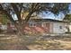 View of a brick house with white trim surrounded by trees and a spacious backyard at 5314 Albert St, North Charleston, SC 29418