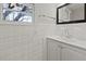 Bright bathroom featuring white tiles, window, and vanity with sink at 5314 Albert St, North Charleston, SC 29418