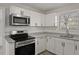 Updated kitchen features stainless steel appliances, granite counters, and white cabinets at 5314 Albert St, North Charleston, SC 29418