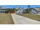 Inviting blue home with a long driveway, well-manicured lawn, and mature trees at 5525 Alpine Dr, Summerville, SC 29483