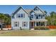 Charming two-story home featuring light blue siding, a manicured lawn, and an inviting orange front door at 5525 Alpine Dr, Summerville, SC 29483