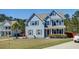 Attractive blue home with an orange front door, complemented by lush landscaping and a well-kept lawn at 5525 Alpine Dr, Summerville, SC 29483