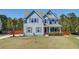 Charming two-story home with light blue siding, orange front door, manicured lawn, and mature landscaping at 5525 Alpine Dr, Summerville, SC 29483