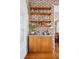 Charming bar area with wood cabinets, marble countertop, brick wall, and open shelving for glassware at 56 Parkwood Ave, Charleston, SC 29403