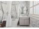 Elegant bathroom featuring a soaking tub, stylish wallpaper, and a vanity with storage and sleek fixtures at 56 Parkwood Ave, Charleston, SC 29403