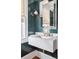 Stylish powder room featuring a marble sink, modern faucet, and unique emerald green walls at 56 Parkwood Ave, Charleston, SC 29403