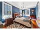 Stylish bedroom features a sleek chandelier, rich blue walls, and beautiful hardwood floors at 56 Parkwood Ave, Charleston, SC 29403