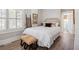 Inviting bedroom featuring crisp white bedding, shuttered windows, and a glimpse into the ensuite bathroom at 56 Parkwood Ave, Charleston, SC 29403