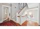 Bright entryway with hardwood floors, white trim staircase, and natural light from the nearby windows at 56 Parkwood Ave, Charleston, SC 29403