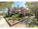 Two-story brick home with manicured landscaping, a white fence, and classic architectural details at 56 Parkwood Ave, Charleston, SC 29403