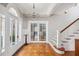 Grand foyer featuring hardwood floors, elegant french doors, a staircase, and lots of natural light at 56 Parkwood Ave, Charleston, SC 29403