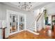 Elegant foyer featuring hardwood floors, glass french doors, staircase, and decorative chandelier at 56 Parkwood Ave, Charleston, SC 29403