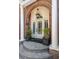 Elegant brick home entrance with a classic white door, columns, and manicured planters at 56 Parkwood Ave, Charleston, SC 29403