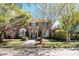 Charming brick home featuring a well-manicured lawn, beautiful trees, and classic architectural details at 56 Parkwood Ave, Charleston, SC 29403