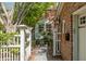 Charming brick home featuring a gated front yard with lush greenery and a brick pathway at 56 Parkwood Ave, Charleston, SC 29403