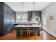 Beautiful kitchen features an island with bar seating, marble counters, and modern gray cabinetry at 56 Parkwood Ave, Charleston, SC 29403