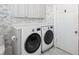 Modern laundry room with elegant wallpaper and a new LG washer and dryer set with white marble floors at 56 Parkwood Ave, Charleston, SC 29403