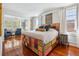 Bright main bedroom featuring wood floors, colorful bed with storage, sitting room, and bright windows at 56 Parkwood Ave, Charleston, SC 29403
