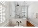 Close-up of bathroom shower area with marble tile, glass door, and black hardware at 56 Parkwood Ave, Charleston, SC 29403