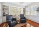 Cozy sitting area featuring hardwood floors, custom built-ins, window seat, and two plush chairs at 56 Parkwood Ave, Charleston, SC 29403