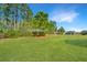 Expansive backyard with lush green grass, mature trees and neighboring homes in the background at 566 Four Seasons Blvd, Summerville, SC 29486