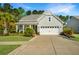 Charming single Gathering home featuring an attached two car garage, manicured lawn, and mature landscaping at 566 Four Seasons Blvd, Summerville, SC 29486