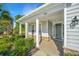 Inviting front porch with stone accents, white columns, and lush landscaping at 566 Four Seasons Blvd, Summerville, SC 29486