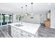 Kitchen island with stainless steel dishwasher and sink under three pendant lights at 566 Four Seasons Blvd, Summerville, SC 29486