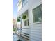 Stylish two-story home featuring a welcoming porch with hanging ferns and modern design elements at 7 Fields Pl, Charleston, SC 29403