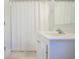 Close-up of a bright bathroom featuring white vanity, mirror, chrome faucet, and shower with curtain at 772 Preservation Pl, Mount Pleasant, SC 29464