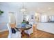 Cozy dining area with a round table, decorative chandelier, hardwood floors, and elegant wainscoting at 772 Preservation Pl, Mount Pleasant, SC 29464