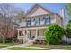 Charming two-story home with a welcoming front porch, complemented by lush landscaping and an American flag at 772 Preservation Pl, Mount Pleasant, SC 29464