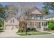 Two-story home with an attached garage, complemented by lush landscaping and an American flag on the porch at 772 Preservation Pl, Mount Pleasant, SC 29464