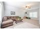 Cozy living room featuring a comfortable brown sectional, a ceiling fan, and neutral-toned decor and carpeting at 772 Preservation Pl, Mount Pleasant, SC 29464