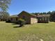 Rear view of a single-story brick home, showing the big lawn and roof at 7819 Bells Hwy, Ruffin, SC 29475