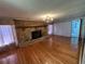 Spacious living room with hardwood floors, stone fireplace, and elegant chandelier at 7819 Bells Hwy, Ruffin, SC 29475